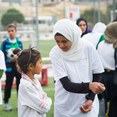 Trainers give instructions on football, girls football, Jordan